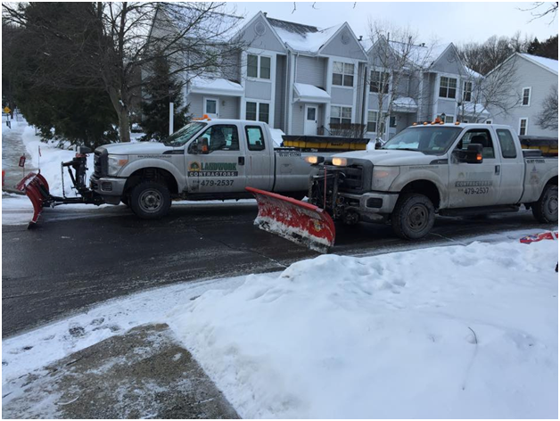 two-white-pickups-plowing-streets-Landwork-Contractors